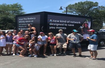 Digital LED billboard truck displayed on the streets with people taking photo with it.