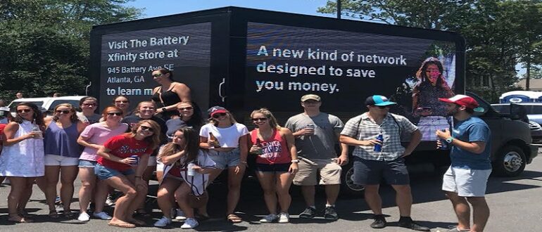 Digital LED billboard truck displayed on the streets with people taking photo with it.